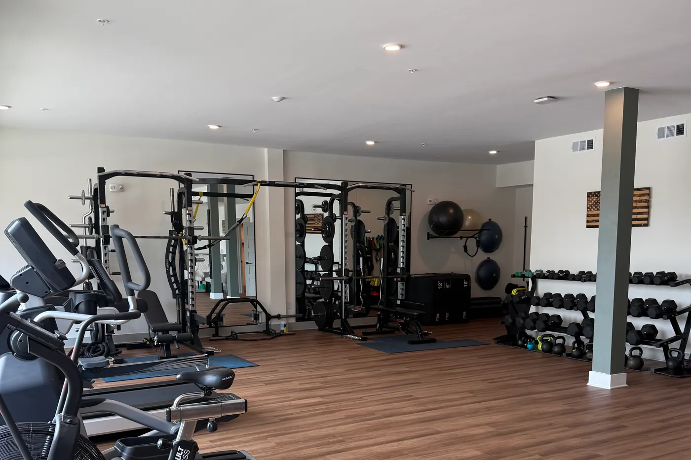 Racks, benches and cardio equipment along the far wall of the studio.